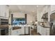 Modern kitchen features stainless steel appliances, white cabinetry, and a spacious island with sink at 556 Moon Shell Cir, New Smyrna Beach, FL 32168
