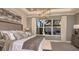 Luxurious primary bedroom with large window overlooking the screened pool, elegant decor and furnishings at 556 Moon Shell Cir, New Smyrna Beach, FL 32168