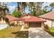 Aerial shot of a home with a red tile roof, lush landscaping, and driveway at 7 Forest Ln, Eustis, FL 32726
