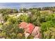 Stunning aerial view showcasing the property's tile roof and lush surroundings near a beautiful lake at 7 Forest Ln, Eustis, FL 32726
