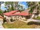 Aerial view of a landscaped home featuring a vibrant red tile roof at 7 Forest Ln, Eustis, FL 32726