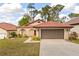 Charming single-story home with a red tile roof, arched entryway, and well-manicured landscaping at 7 Forest Ln, Eustis, FL 32726