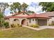Charming single-story home featuring a red tile roof, arched entryway, and a well-maintained landscaped front yard at 7 Forest Ln, Eustis, FL 32726