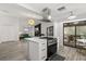 Contemporary kitchen with a cooktop island, stainless steel appliances, and adjacent living space at 7 Forest Ln, Eustis, FL 32726