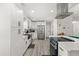 Bright, modern kitchen with stainless steel appliances, white cabinets, and island cooktop at 7 Forest Ln, Eustis, FL 32726
