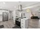 Open-concept kitchen with stainless steel appliances, a center island with cooktop, and wood-look flooring at 7 Forest Ln, Eustis, FL 32726