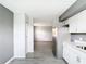 Kitchen featuring white cabinets, stainless steel appliances, and sleek gray flooring into the living room at 734 Michigan Ct # 2, St Cloud, FL 34769