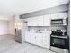 Well-lit kitchen featuring white cabinets, stainless steel appliances, and modern fixtures at 734 Michigan Ct # 2, St Cloud, FL 34769