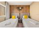 Cozy bedroom featuring two twin beds, a wood accent wall, and yellow pillows at 7513 Brooklyn Dr, Kissimmee, FL 34747