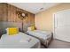 Charming bedroom featuring two twin beds, unique wood accent wall, and ample lighting at 7513 Brooklyn Dr, Kissimmee, FL 34747