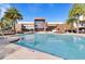 Large swimming pool with clear water surrounded by lounge chairs and palm trees on a sunny day at 7513 Brooklyn Dr, Kissimmee, FL 34747