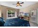 Bedroom featuring a window with views, a ceiling fan, workspace area, and access to the outdoors at 7672 Torino Ct, Orlando, FL 32835