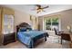 Comfortable bedroom with a ceiling fan, a large window, and a cozy workspace for focused productivity at 7672 Torino Ct, Orlando, FL 32835
