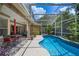 Inviting screened-in pool area with comfortable seating, lush landscaping, and serene outdoor space at 7672 Torino Ct, Orlando, FL 32835
