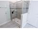 Modern bathroom featuring a glass-enclosed shower with gray tile surround and built-in shelving at 8912 Cabot Cliffs Dr, Davenport, FL 33896