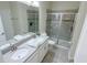 Modern bathroom featuring double sinks, quartz counters, and a glass-enclosed shower at 8912 Cabot Cliffs Dr, Davenport, FL 33896