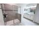 Bathroom with glass shower, double sink vanity, large mirror, and gray tile flooring at 8912 Cabot Cliffs Dr, Davenport, FL 33896