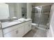 Bathroom with double sink vanity, granite countertops, and a glass-enclosed shower for a spa-like experience at 8912 Cabot Cliffs Dr, Davenport, FL 33896