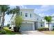 Beautiful two-story house with a stone chimney, a gray garage door, and lush greenery at 8912 Cabot Cliffs Dr, Davenport, FL 33896