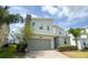 Charming two-story home with a stone facade, a gray garage door, and a well-kept lawn at 8912 Cabot Cliffs Dr, Davenport, FL 33896