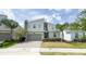 Modern two-story house with stone details, a gray garage door, and neat front lawn at 8912 Cabot Cliffs Dr, Davenport, FL 33896