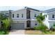 Contemporary two-story home featuring mixed material exterior, brick paver driveway, and two-car garage at 8912 Cabot Cliffs Dr, Davenport, FL 33896