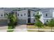 Aerial view of a modern two-story home with stone accents and a well-maintained front yard at 8912 Cabot Cliffs Dr, Davenport, FL 33896