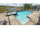 Backyard view of a screened-in pool and spa, with outdoor lake views and a brick paver deck at 8912 Cabot Cliffs Dr, Davenport, FL 33896