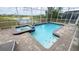 Sparkling pool and spa with a brick paver deck, with scenic water views and screened enclosure at 8912 Cabot Cliffs Dr, Davenport, FL 33896
