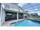 Backyard view of a screened-in pool and spa, with outdoor seating area and spacious patio at 8912 Cabot Cliffs Dr, Davenport, FL 33896