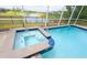 Soothing spa and pool with serene lake views, enclosed with a screen and secured with a fence at 8912 Cabot Cliffs Dr, Davenport, FL 33896