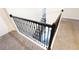 Staircase featuring black metal railings and neutral carpeting at 8912 Cabot Cliffs Dr, Davenport, FL 33896