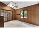 Bedroom featuring wood paneled walls, a ceiling fan, french doors, a single window, and a shelf on the wall at 102 Wild Plum Ln, Longwood, FL 32779