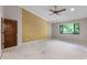 Large bedroom featuring a ceiling fan, an accent wall, and a window overlooking the backyard and greenery at 102 Wild Plum Ln, Longwood, FL 32779