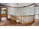 Upper hallway with decorative wallpaper and a wooden banister, with a bedroom doorway visible at 102 Wild Plum Ln, Longwood, FL 32779