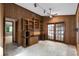Office featuring wood paneled walls, a ceiling fan, french doors, a window, and a desk with storage above and below at 102 Wild Plum Ln, Longwood, FL 32779