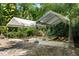 Features a semi-permanent outdoor canopy structure surrounded by lush trees, shrubs, and tropical vegetation at 102 Wild Plum Ln, Longwood, FL 32779