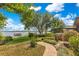 Beautiful backyard with a brick path, lush landscaping, mature trees, and serene lake views at 10577 Down Lakeview Cir, Windermere, FL 34786