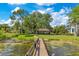 Expansive backyard featuring a lake view, private dock, mature trees, and lush landscaping at 10577 Down Lakeview Cir, Windermere, FL 34786