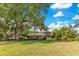 A meticulously maintained backyard with mature trees, a large manicured lawn, and landscaping at 10577 Down Lakeview Cir, Windermere, FL 34786