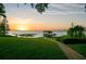 Sunset view of boat dock on a serene lake with lush greenery and a clear sky, offering a tranquil setting at 10577 Down Lakeview Cir, Windermere, FL 34786
