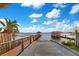 Beautiful waterfront property with wooden dock and boat lift on a serene lake under a sunny sky at 10577 Down Lakeview Cir, Windermere, FL 34786
