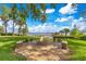 Charming stone fire pit with seating, perfect for outdoor gatherings with lake views at 10577 Down Lakeview Cir, Windermere, FL 34786