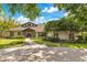 Charming home with a well-manicured lawn, lush landscaping, and a welcoming pathway leading to the entrance at 10577 Down Lakeview Cir, Windermere, FL 34786