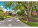 Beautiful home with mature trees, a brick driveway, lush landscaping, and an American flag at 10577 Down Lakeview Cir, Windermere, FL 34786