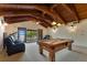 Well-lit game room with a pool table, comfortable seating, exposed ceiling beams and large windows at 10577 Down Lakeview Cir, Windermere, FL 34786