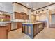 Spacious kitchen showcasing custom wood cabinetry, granite counters, large island, and designer pendant lighting at 10577 Down Lakeview Cir, Windermere, FL 34786
