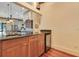 Entertainer's kitchen bar area with granite countertops, wood cabinets, and a built-in wine refrigerator at 10577 Down Lakeview Cir, Windermere, FL 34786