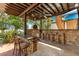 Outdoor kitchen with pizza oven, stone bar with seating, and a flat screen tv at 10577 Down Lakeview Cir, Windermere, FL 34786
