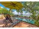 Relaxing pool area with lounge chairs, umbrella, and stunning lake views at 10577 Down Lakeview Cir, Windermere, FL 34786
